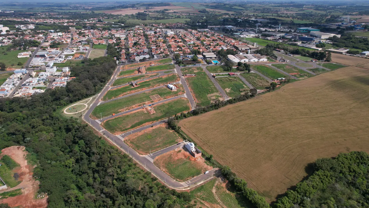 Vista aérea das quadras do loteamento, com as primeiras casas em construção e a mata ao lado